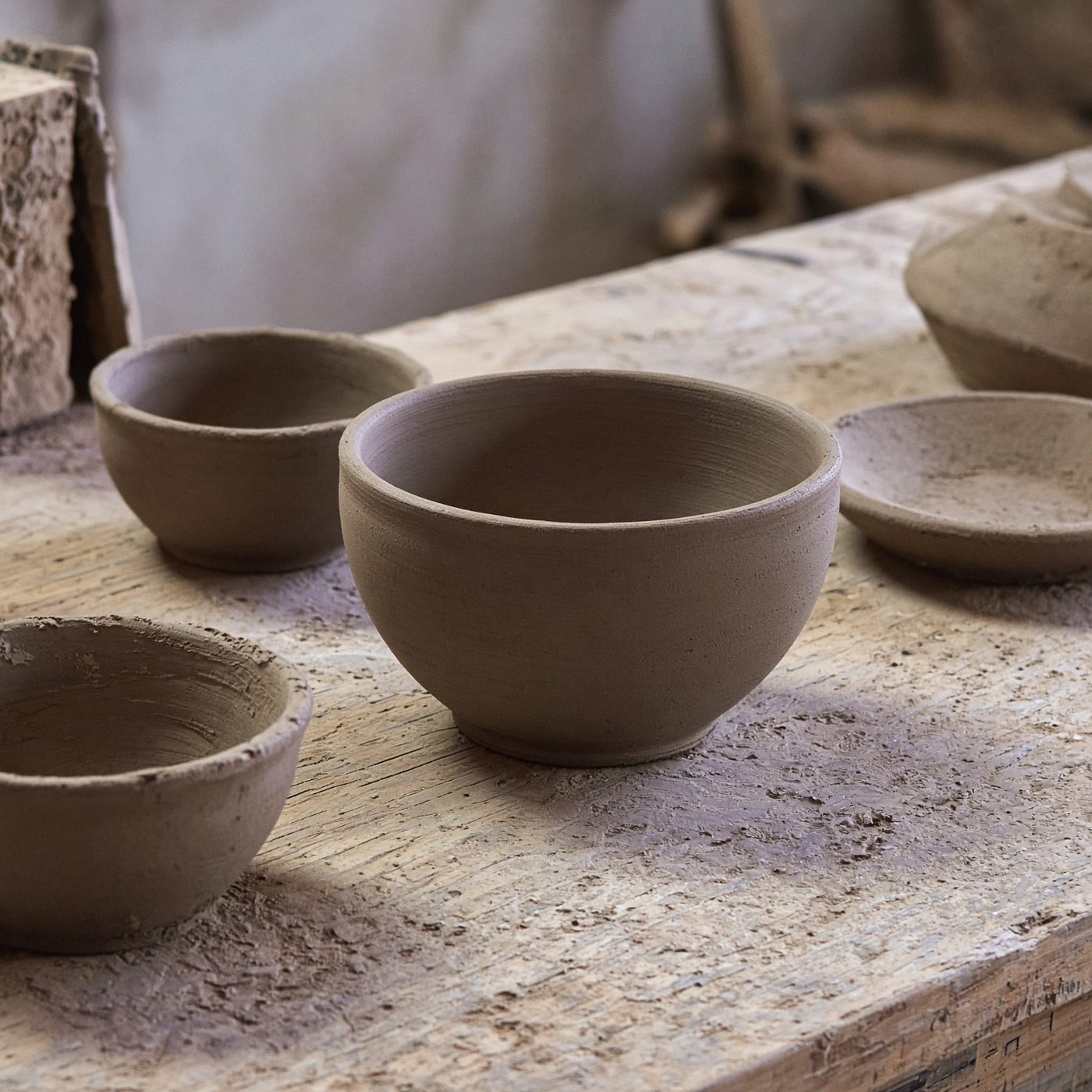 Unfired clay bowls on a workbench
